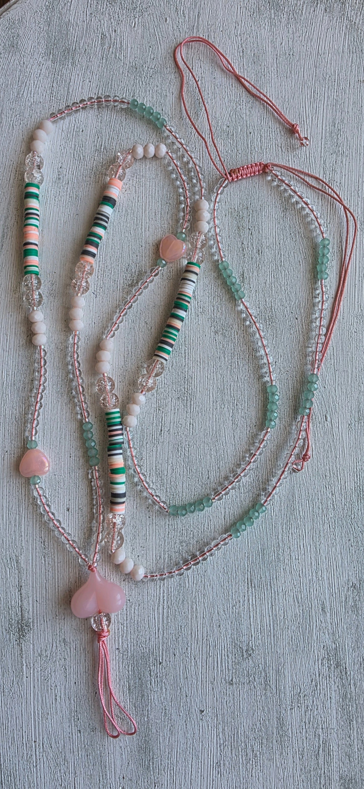 Pink heart beaded phone strap necklace with mint green accents and heart charm pendant